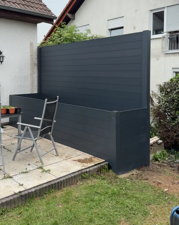 Sichtschutzwand aus Aluminium in Anthrazit mit angebautem Hochbeet an einer Terrasse